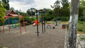 a playground with a bunch of playground equipment in a park at Гостевой домик in Chornomorsk