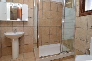 a bathroom with a shower and a sink at Arsinoi Stonehouses in Limenaria