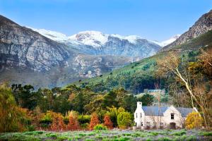 フランシュホークにあるLavender Farm Boutique Guest Houseの山を背景にした畑の古民家