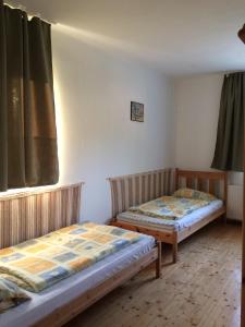 dwa łóżka w pokoju z oknem w obiekcie Fasor vendégház w mieście Balatonszemes