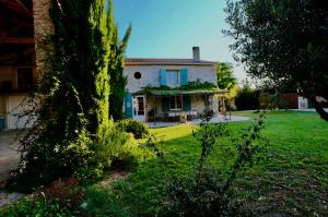 una casa con un patio verde delante de ella en Maison de Margot, en Peyriac-Minervois