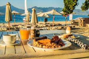 龍目島的住宿－Scallywags Beach Club，海滩上一张桌子和一盘食物