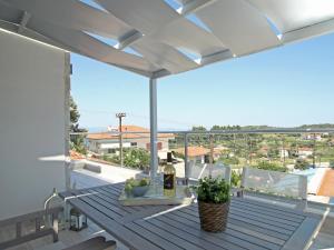 un tavolo da patio con una bottiglia di vino sul balcone di Imagine Studios a Paliouri