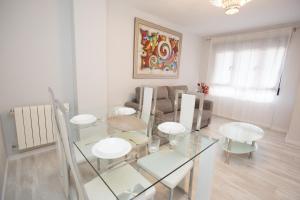 a white living room with a glass table and chairs at Center Deluxe in Granada +9 photos