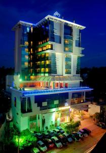 a building with cars parked in front of it at night at SP Grand Days in Trivandrum