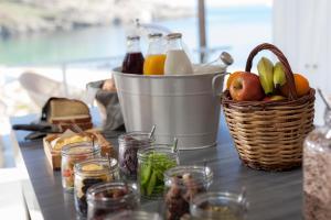 a table with a bucket of milk and a basket of fruit at Coco-Mat Eco Residences Serifos in Vayiá