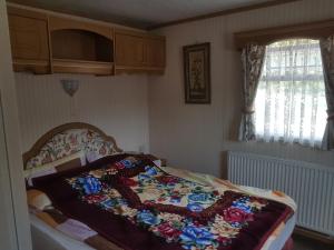 a bedroom with a bed with a blanket on it at Agroturystyka Perła Gaju in Wojciechów