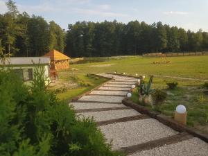 a stone path leading to a field with a house at Agroturystyka Perła Gaju in Wojciechów