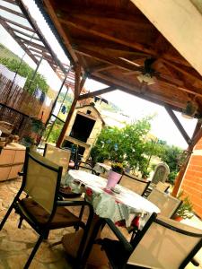 a table and chairs on a patio with a roof at Holiday Home Listeši in Trogir