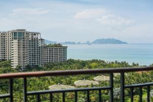 een balkon met uitzicht op de oceaan en gebouwen bij Howard Johnson Resort Sanya Bay in Sanya