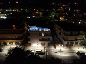 une ville la nuit avec des voitures garées dans un parking dans l'établissement Appartamenti DeSi, à Tropea