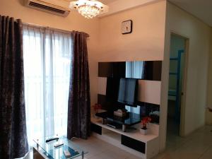 sala de estar con TV y ventana grande en Apartment Cosmo Terrace en Yakarta