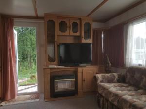 a living room with a couch and a flat screen tv at Agroturystyka Perła Gaju in Wojciechów