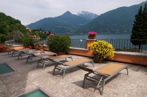 a row of tables and chairs on a balcony with a lake at Hotel Sole in San Siro