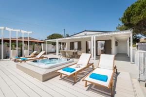 patio con sedie e terrazza con vasca idromassaggio. di Sea View White Villa a Stavros