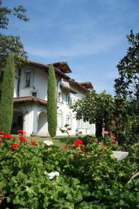 dom z ogrodem z czerwonymi i białymi kwiatami w obiekcie Villagaia Country House w mieście Montafia