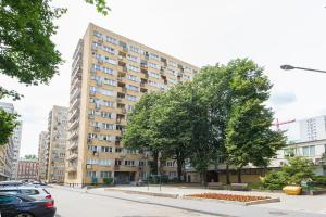 a tall building on a city street with cars at oompH Warsaw Downtown Apartments in Warsaw