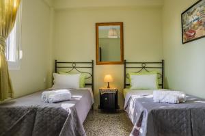 a room with two beds and a lamp and a mirror at Le Paradis d' Elli in Lakíthra +40 photos