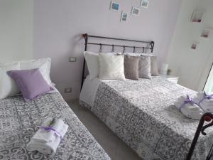 two beds in a bedroom with purple and white at Stella di Mare in La Spezia