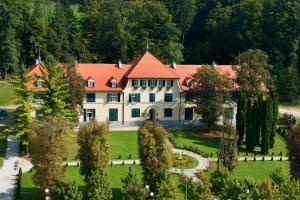 uma grande casa branca com um telhado vermelho em Apartments Vila Golf - Flucher Turizem em Rogaška Slatina