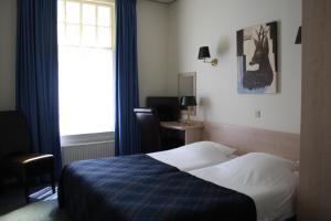 Habitación de hotel con cama y ventana en 't Witte Hoes en Otterlo