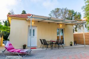 a patio with a table and chairs and an umbrella at Le Paradis d' Elli in Lakíthra