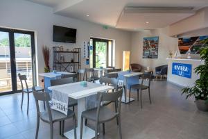 une salle à manger avec des tables et des chaises dans un restaurant dans l'établissement Riviera HUB, à Cisano sul Neva