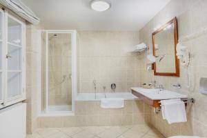 un bagno con vasca, lavandino e doccia di Boutique Hotel Constans a Praga