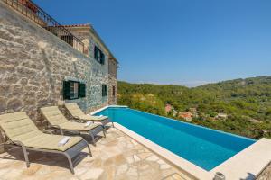 a villa with a swimming pool and chairs on a patio at Villa Klacina in Goveđari