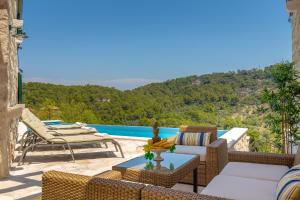 eine Terrasse mit Stühlen, einem Tisch und einem Pool in der Unterkunft Villa Klacina in Goveđari