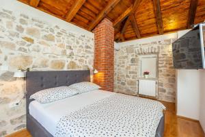 a bedroom with a bed in a stone wall at Villa Klacina in Goveđari +17 photos