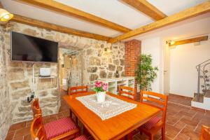 a dining room with a wooden table and chairs at Villa Klacina in Goveđari