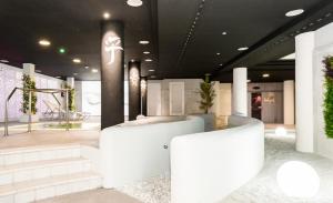 a lobby with white walls and stairs and plants at TUI Blue Isla Cristina Palace - Adults Recommended in Isla Cristina