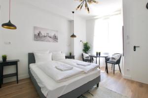 ein weißes Schlafzimmer mit einem Bett und einem Tisch in der Unterkunft Luxury Apartment by Hi5 - Régiposta in Budapest