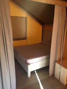a small bed in a room with a window at agricampeggio GLAMPING MARCONI in Veglie