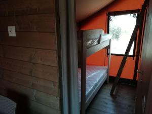 a bunk bed in a cabin with a window at agricampeggio GLAMPING MARCONI in Veglie