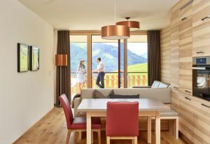 kuchnia i jadalnia ze stołem i krzesłami w obiekcie Residenz Tirol w mieście Lechleiten