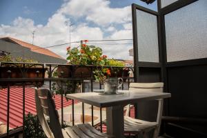 a small table and chairs on a balcony at B&B Al Centro Storico in Nicolosi