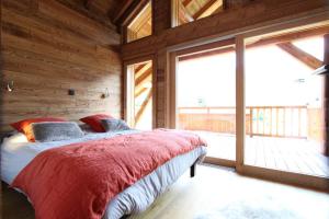 ラ・サル・レ・ザルプにあるChalet Petit Cerfのベッドルーム1室(ベッド1台、大きな窓付)