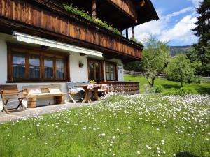 a house with a picnic table and a field of flowers at Haus Thomas in Alpbach