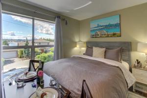 een slaapkamer met een groot bed en een groot raam bij Blue Angels Room Mercer Island in Mercer Island
