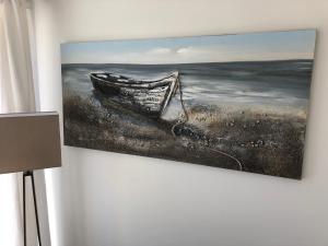 a painting of a boat hanging on a wall at Bournemouth Hot Tub & Sauna Holiday Let in Bournemouth
