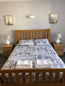 a bed with two nightstands and two lamps at Bournemouth Hot Tub & Sauna Holiday Let in Bournemouth