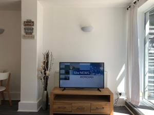 a flat screen tv sitting on a wooden stand in a living room at Bournemouth Hot Tub & Sauna Holiday Let in Bournemouth
