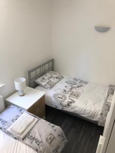 a bedroom with two beds and a table with a lamp at Bournemouth Hot Tub & Sauna Holiday Let in Bournemouth