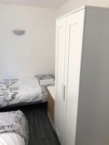 a bedroom with two beds and a white cabinet at Bournemouth Hot Tub & Sauna Holiday Let in Bournemouth