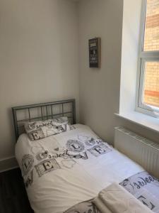 a small bedroom with a bed with white sheets at Bournemouth Hot Tub & Sauna Holiday Let in Bournemouth