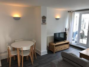 a living room with a table and a tv at Bournemouth Hot Tub & Sauna Holiday Let in Bournemouth