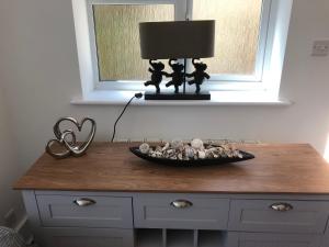a table with a lamp and a bowl of rocks on it at Bournemouth Hot Tub & Sauna Holiday Let in Bournemouth