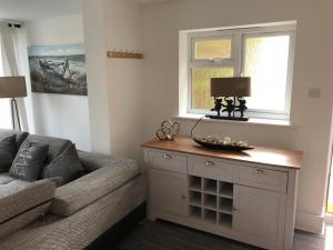 a living room with a couch and a window at Bournemouth Hot Tub & Sauna Holiday Let in Bournemouth